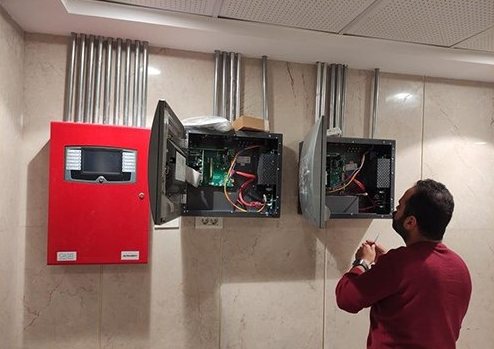 Fire alarm control panel being checked by a technician